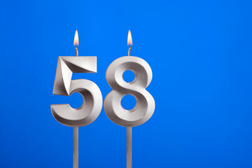 Birthday candle number 58 - Celebration card on blue background