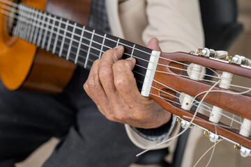 details of a musical chord on a guitar, hands of a person playing instruments with strings,...