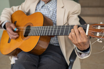Obraz premium hands of a person playing the guitar, musical instrument with strings, lifestyle of artist playing a song, detail of objects as background