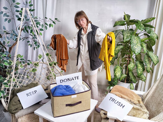 Middle-Aged Woman Sorting Belongings With KonMari Method. Mature woman categorizes items into keep...