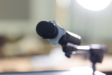 Fototapeta premium Closeup shot of an audio equipment microphone on a metal stand at a podium