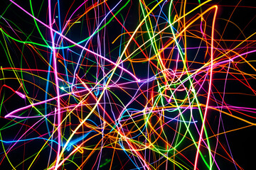 Colorful neon lines intersecting in a vibrant dance. Stunning abstract artwork on black background.