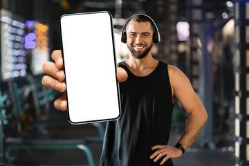 Smiling Man in a Black Tank Top Shows Blank Smartphone
