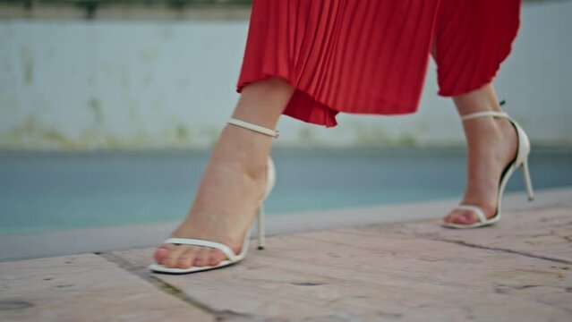Woman feet walking fountain border at summer weekend closeup. Windy evening