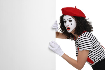 Funny mime with blank poster posing on white background