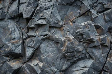 Wall of rocks displaying multiple cracks and holes. Geological feature in rugged terrain.