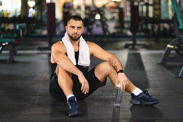 Man Sitting on the Ground in a Gym