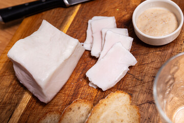 Delicious sliced lard served with bread and horseradish on board