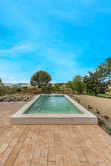 a beautiful recreational pool at the foot of a large garden with spectacular views