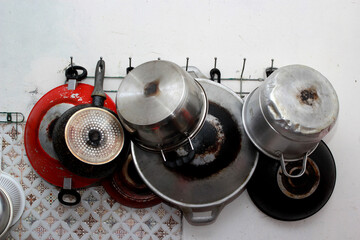 a collection of pots and pans hanging on the wall