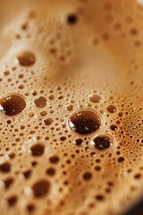 A macro photo of coffee texture with foam and bubbles.