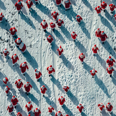 Seamless pattern of numerous Santa Clauses walking on snow, aerial view