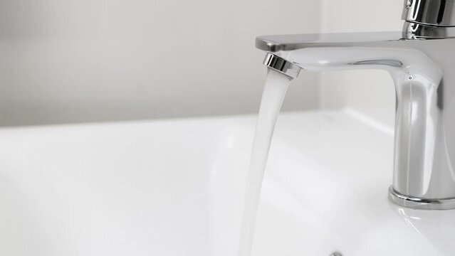Water running from faucet closeup. Nobody
