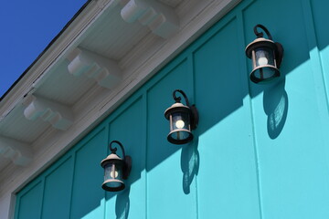 Lantern style lighting on side of teal colored building.