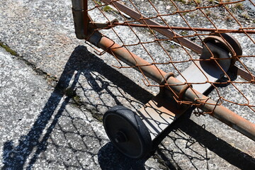 Chain-link fence gate wheels, rusted.