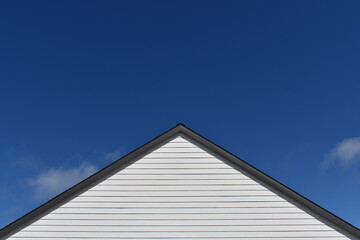 Roof peak against deep blue sky.