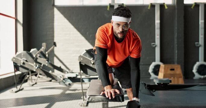 Man, fitness and weightlifting with dumbbell at gym in workout, exercise or indoor training. Portrait of weak male person or funny nerd lifting small barbell in muscle gain or strength at health club