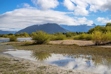 Reflection of the mountains in a water, autumn season, area of the Lake Wakatipu, New Zealand, South Island