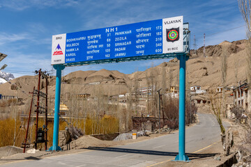 Blue sign marking mileages on India National Highway One in the Ladakh region in the Himalayas