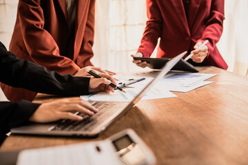 Diverse group of professionals businesswomen gather in meeting room for collaborative discussions on finance, strategy, and teamwork, technology tablets and laptops for data analysis and presentation