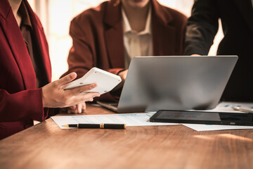 Diverse group of professionals businesswomen gather in meeting room for collaborative discussions on finance, strategy, and teamwork, technology tablets and laptops for data analysis and presentation