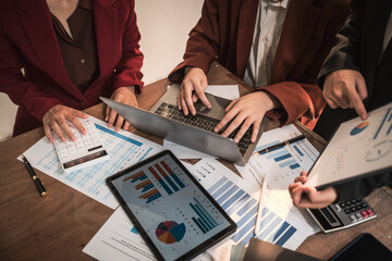 Diverse group of professionals businesswomen gather in meeting room for collaborative discussions on finance, strategy, and teamwork, technology tablets and laptops for data analysis and presentation