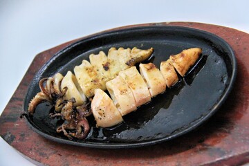 Grilled squids or 'Cumi Bakar' is a sweet and tangy seafood dish that is often sold as street food in Indonesia. It is marinated in sweet soy sauce and a mixture of spices before being grilled. 