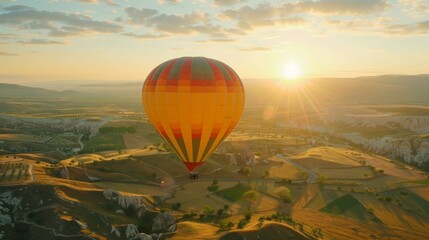 A colorful hot air balloon floats gracefully above a vibrant, green field. The balloon casts a shadow on the grass below as it glides through the clear blue sky.