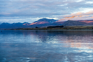 Fototapeta na wymiar Lake Tekapo and the cloudy mountains in the evening 