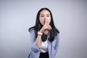 Pretty Asian Woman in Casual Style Make a Silence Gesture, Be Quiet Please for Education Concept