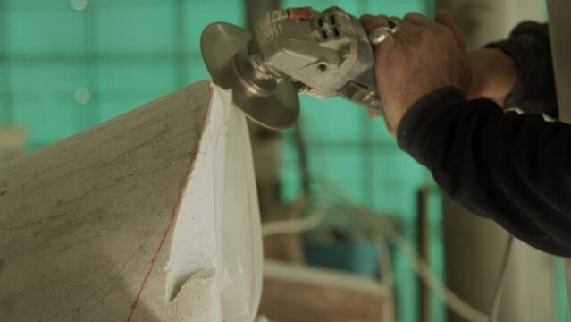 Man grinding stone with a power tool in a workshop