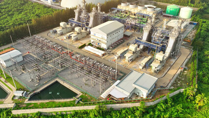 A sprawling power plant, seen from above by drone, dominates the landscape with its massive turbines and steel structures. Electrical energy concept. 


