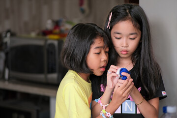 Two little girls playing together at home during school holiday