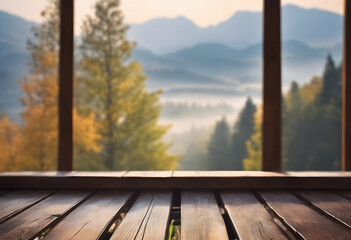 View of a misty mountain landscape from a wooden deck, framed by wooden beams, during sunrise.