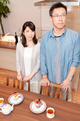 テーブルの前に立つ中年夫婦