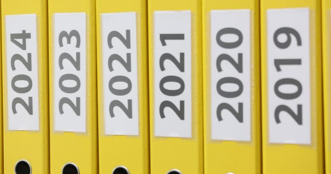 Yellow folders with dates from 2018 to 2028 closeup
