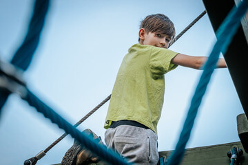 boy climbing on a childrens slide at the playground in the park
