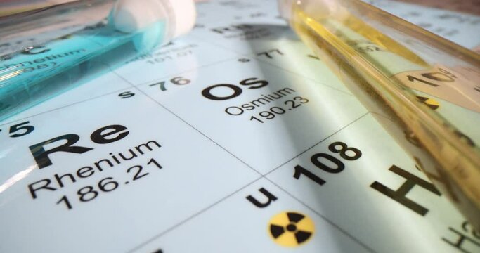 Chemical elements and test tubes with yellow and blue liquids on the periodic table of chemical elements