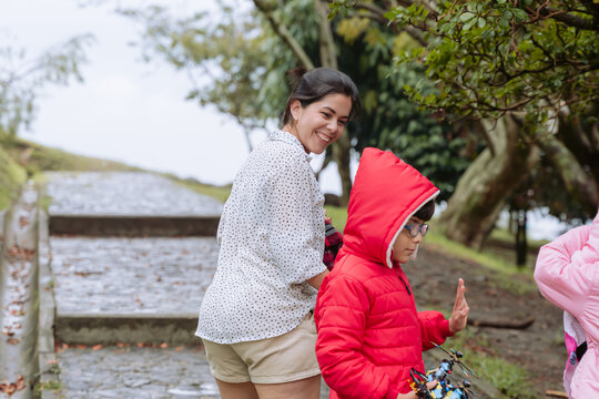 International Children Day. Tender Latina mother with her children on a family day outdoors. Single mom of two children. Nature and love. Copy space.