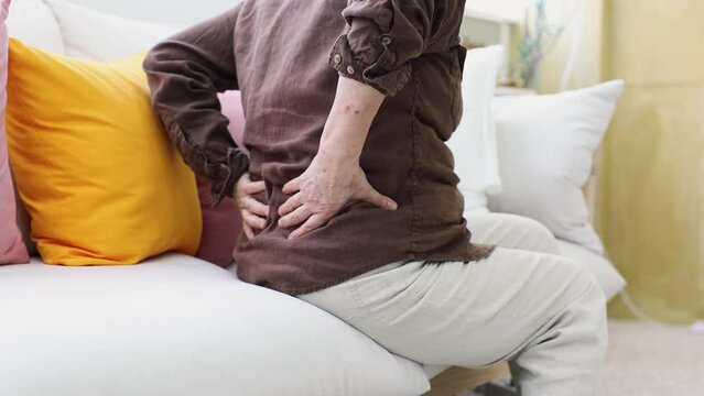 An elderly woman complaining of pain from herniated disc in her back