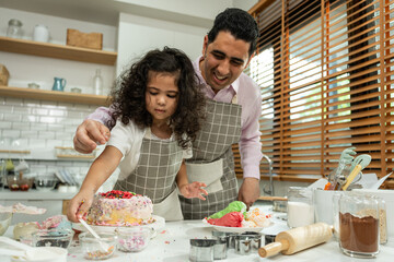 Asian attractive father making cake with daughter in kitchen at house. 