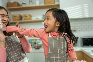 Asian attractive mother making cake with daughter in kitchen at house. 