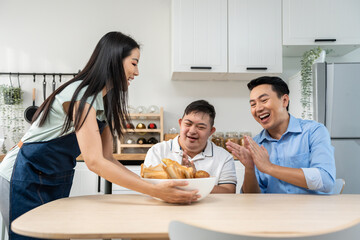 Asian happy family, mature parent having breakfast with son in kitchen. 