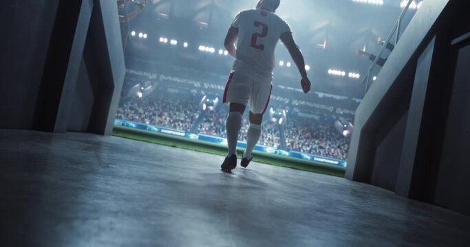 Caucasian Soccer Player Walking Through a Dark Tunnel Entrance to a Big Outdoors Stadium Filled with Energetic Sports Fans and Team Supporters. Footballer Appreciating Support Before a Match