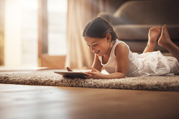 Girl, happy and playing with tablet on carpet for digital education, ebook and child development in...