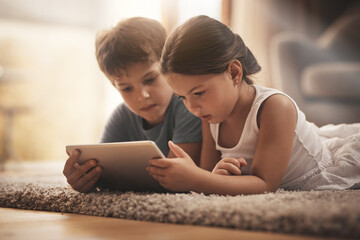 Children, video and watching with tablet on floor for digital education, ebook and learning in...