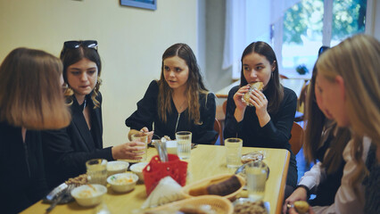 Obraz premium Senior girls having breakfast in the school canteen.