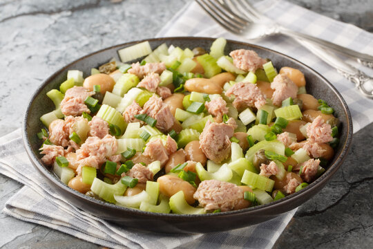 White Bean, Tuna and Celery Salad with vinaigrette sauce closeup on the plate on the table. Horizontal
