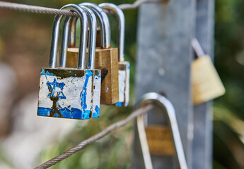 Castles symbolize unity and love forever. Locks hang on fence ropes in park. Tradition of locking...
