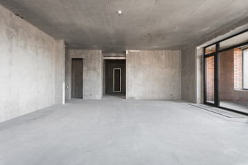 Obraz premium interior of the apartment without decoration in gray colors. rough finish